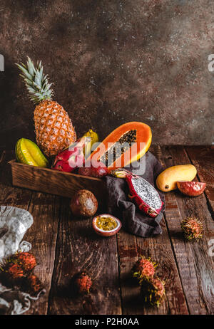 Carambolas, papayes, ananas, fruits de la passion, ramboutans et mangue sur table en bois Banque D'Images