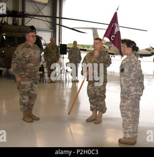 HOPE HULL, Ala. (sept. 17, 2016) -- Le Capitaine Ryan J. Langhammer (centre) tient le guidon portant les couleurs de l'unité de détachement 2, l'entreprise C (Air Ambulance), 1er Bataillon, 111e Régiment d'aviation, 122e Commande des troupes, Alabama Army National Guard pour la première fois en tant qu'il devient le premier commandant du détachement nouvellement activé lors d'une cérémonie pour activer l'unité à l'aviation de l'Armée de soutien # 1, Fort R. W. Shepherd armoirie, ici, le 17 septembre 2016. Le colonel Zachary E. Maner (à gauche), le commandant de la 122e Commande des troupes, la Garde nationale de l'Alabama, et le sergent. Elaine Sprui Banque D'Images