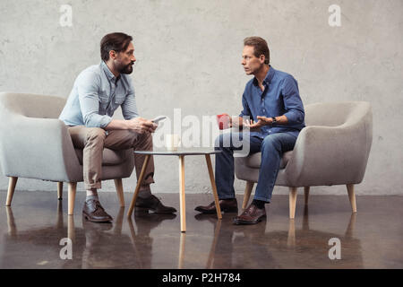 Les hommes d'affaires occasionnels au cours de parler à la pause café réunion Banque D'Images