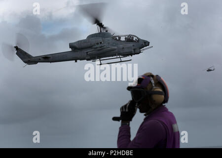 Le 19 septembre 2016, un hélicoptère d'attaque AH-1W Super Cobra a effectué des opérations aériennes au-dessus de l'USS Bataan (LHD-5) pendant la formation d'intégration de l'unité expéditionnaire des Marines amphibies en mer. L'AH-1W, bimoteur et rotor à deux pales, prend en charge le soutien aérien rapproché et les opérations expéditionnaires. Les pilotes du Marine Medium Tiltrotor Squadron 365 (REIN), qui fait partie de la 24e MEU, ont maintenu leurs compétences en vol, leur état de préparation opérationnelle et pratiqué l'intégration coordonnée avec les moyens amphibies et navals. Banque D'Images