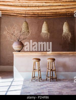 Lanternes en rotin bambou suspendu au-dessus de comptoir de bar en bar avec plafond en bois et de sols en marbre. L'antique pot vient de l'Afrique de l'Est Banque D'Images