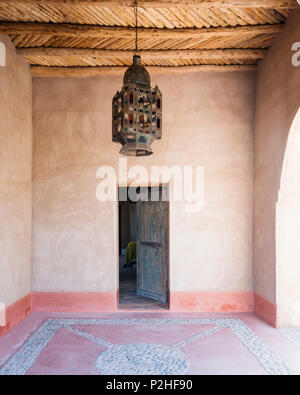 Grande lanterne marocain suspendu du plafond en bois dans la cour d'entrée d'une maison berbère Banque D'Images