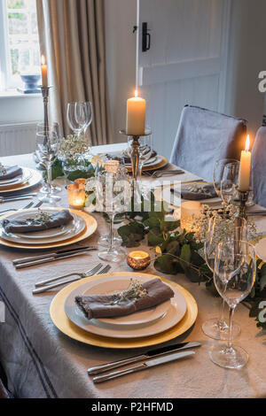 Candle lit table à manger pour un repas de fête et habillé de tissu de Maison Brocante Banque D'Images