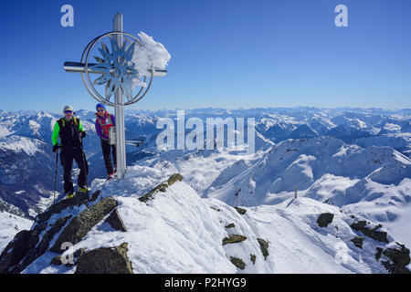 L'homme et la femme ski debout à la croix au sommet du Schneespitze Schneespitze,, la vallée de Stubai, Pflersch Banque D'Images