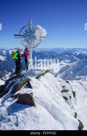 L'homme et la femme ski debout à la croix au sommet du Schneespitze Schneespitze,, la vallée de Stubai, Pflersch Banque D'Images