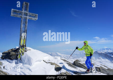 Femme ski ordre croissant vers cross, au sommet du Monte, Monte Salza Salza, Valle Varaita, Alpes Cottiennes, Piémont, Banque D'Images