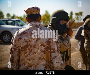 Un entraîneur italien demande à un soldat peshmergas sur la façon de don son masque protecteur au cours d'un incident chimique, biologique, radiologique et nucléaire Défense classe à Bnaslawa, Iraq, 21 septembre 2016. Formation CBRN est fournie aux soldats peshmergas dans le cas où les armes chimiques sont utilisées par l'État islamique d'Irak et du Levant. Cette formation fait partie de la Force opérationnelle interarmées combinée globale - Fonctionnement résoudre inhérent à la mission de renforcer les capacités des partenaires pour accroître la sécurité de la capacité des forces luttant ISIL. (U.S. Photo de l'armée par le Sgt. Lisa soja) Banque D'Images