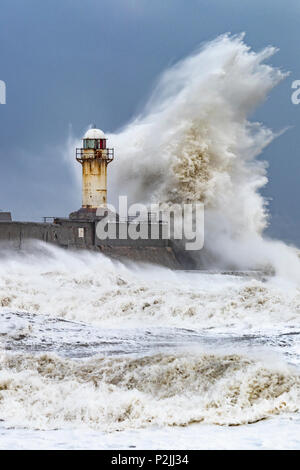 L'état de la mer au sud de la Gare, Redcar, Cleveland. La rupture de l'onde sur le phare. Banque D'Images