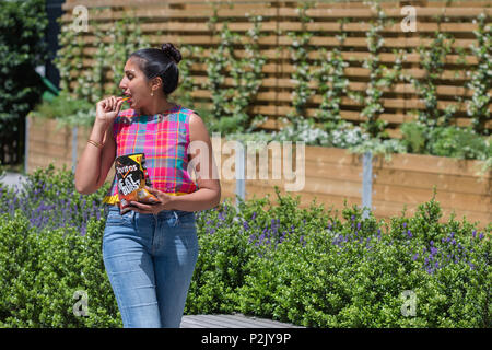 Woman eating Doritos en dehors Banque D'Images