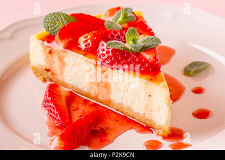 Délicieux gâteau au fromage fait maison avec des fraises sur fond rose. Banque D'Images