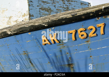 En détresse en bois patiné vieux bateau de pêche bleu jaune avec lettres et nombre d'une vue rapprochée de la coque avec des fissures et peeling p Banque D'Images