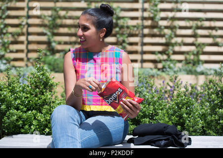 Woman eating Doritos en dehors Banque D'Images