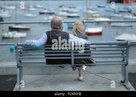 Un couple assis sur un banc au bord de la mer à Falmouth, Cornwall. Banque D'Images