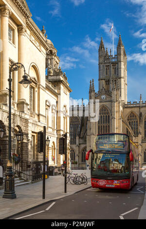 Red bus touristique ci-dessous à l'abbaye de Bath, Bath, Somerset, Angleterre Banque D'Images