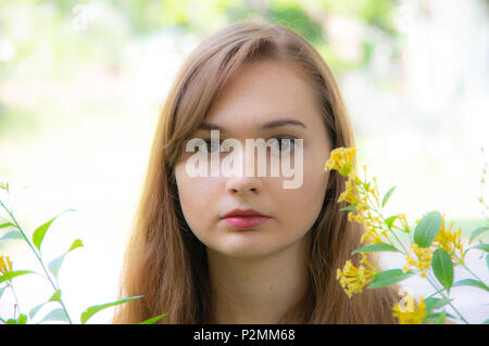 Jolie fille aux cheveux rouge avec des fleurs jaunes Banque D'Images