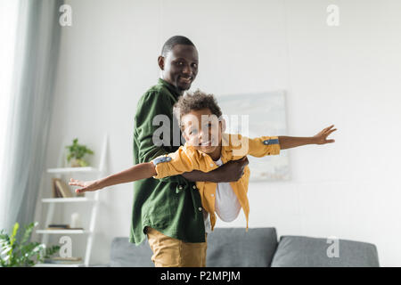 Père et fils d'africains jouant à la maison, prétendant airplane Banque D'Images