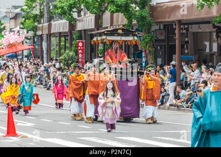 Femme de haut rang dans la main transport tiré par les jeunes hommes et suivie par les filles en kimono lors d'Aoi Matsuri Festival à Kyoto, Japon Banque D'Images