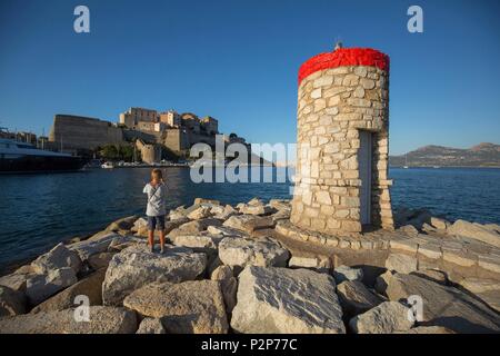 France, Haute Corse, Balagne, Calvi et sa citadelle génoise vu de la jetée du port, jeune garçon prend des photos. Banque D'Images