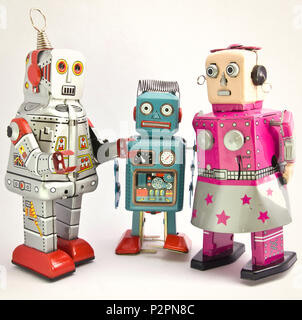 Trois robots jouets rétro ensemble on white Banque D'Images