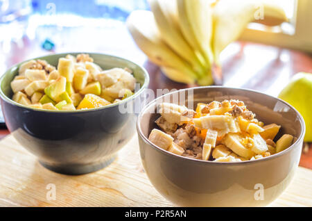 Petit-déjeuner sain Bol : avoine avec de la banane, de l'orange, vert pomme, noix, graines de sésame et Chia Banque D'Images