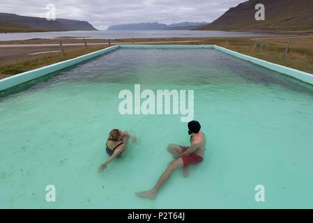 L'Islande, Fjords de l'Ouest, Bildudalur, Reykjarfjordur, couple dans une piscine géothermique au bas de fjord Arnarfjörður Banque D'Images