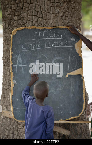 Un garçon pointe vers des lettres sur un tableau noir dans l'école primaire de Loreto à Rumbek, dans le sud du Soudan. Banque D'Images