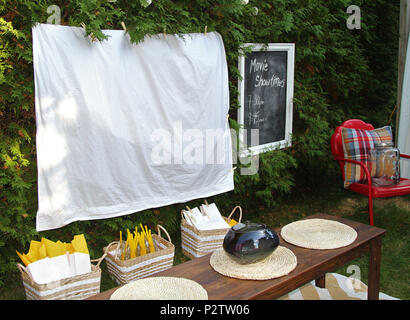 Fiche technique blanc prêt pour une soirée cinéma en plein air avec de la nourriture et des chaises Banque D'Images