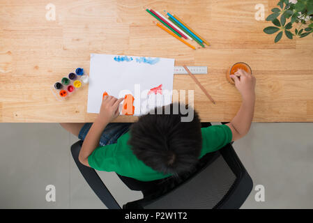 Petit garçon dessine à la table. Vue d'en haut Banque D'Images