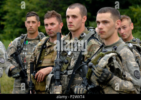 Soldats de la Compagnie Bravo, 3e Bataillon, 116ème Cavalry Brigade Combat Team, écouter d'autres soldats et observateurs contrôleurs examiner les actions et réactions au cours de la formation au combat alors que lors de l'exercice de tuteur 16 Sabre à la terre roumaine, Centre de formation de combat des Forces canadiennes Cincu, Roumanie Le 2 août. Les équipes du scoutisme pour les forces de l'opposition tout en en patrouille et de répondre aux attaques et d'embuscades. Sabre d'exercice 16 Guardian est un exercice militaire multinationale impliquant environ 2 800 militaires provenant de 10 pays y compris l'Arménie, Azerbaïdjan, Bulgarie, Canada, Géorgie, Moldova, Pologne, Roman Banque D'Images