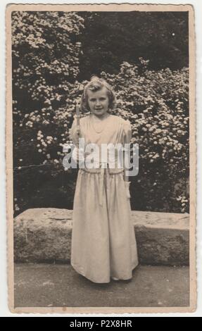 La République tchécoslovaque - Vers les années 1940 : Vintage photo montre fille après sa première communion. Retro noir et blanc de la photographie. Banque D'Images