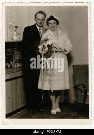 La République socialiste tchécoslovaque - circa 1960 : Vintage photo montre une mariée avec époux. Mariée porte un voile doux et est titulaire d'calla fleurs (bouquet). Retro noir et blanc de la photographie. Banque D'Images