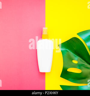 Jungle tropicale Feuilles monstera palmier bouteille vide de l'écran solaire et immersive sur carré lumineux jaune et rose papier duotone arrière-plan. Vacances d'été cre Banque D'Images
