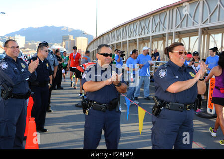 Port d'entrée d'El Paso Los directeur de port, bien droite, et d'autres agents du CBP applaudir comme coureurs terminer la course International U.S.-Mexico course de 10k en haut de la Paso del Norte de passage international à El Paso, Texas, le 8 août 2016. Près de 700 coureurs ont participé à l'événement qui les a conduits sur un cours sur la frontière entre El Paso, Texas, et Juarez, au Mexique. Photo du CBP par Roger Maier Banque D'Images