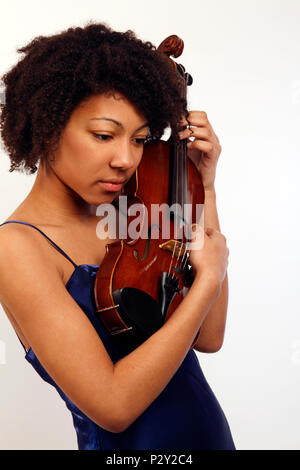 Jeune fille noire tenant son violon jusqu'à proximité de son visage. Banque D'Images