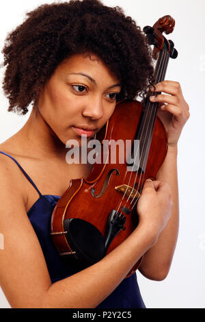 Jeune fille noire tenant son violon jusqu'à proximité de son visage. Banque D'Images