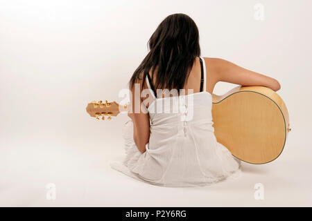 Jeune femme jouant de la guitare - vue arrière Banque D'Images