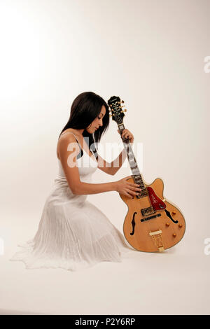 Générique - jeune femme avec une guitare électrique acoustique Banque D'Images