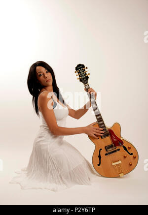 Jeune femme avec une guitare électrique acoustique semi - generic Banque D'Images