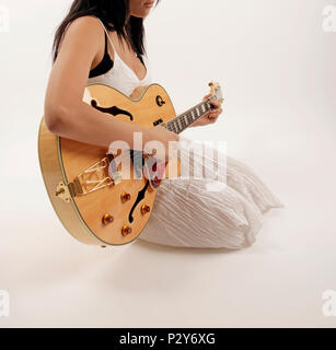 Jeune femme playiing une semi acoustic guitare électrique. Banque D'Images