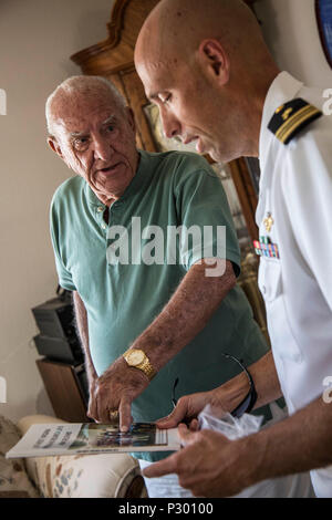 Herbert Crask, un vétéran de la Marine américaine, montre un équipage d'adresses pour le lieutenant Cmdr. Jeltema David, un aumônier avec Naval Medical Center San Diego, après réception de la dunette Bell de l'USS Black Hawk (AD-9) à Trinidad, 9 août 2016. Au cours de ses 10 années d'enrôlement, Crask servi à bord du USS Black Hawk, l'USS West Virginia (BB-48) et l'USS Prairie (AD-15). Banque D'Images