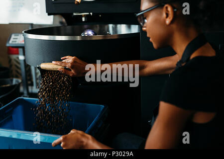 Femme à l'aide de la torréfaction de café barista industrielle machine à café Banque D'Images