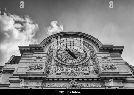 Une sombre, dramatique, de l'image de l'horloge sur le dessus de la musée d'Orsay à Paris. Anciennement la Gare d'Orsay gare, avec des trains circulant entre Paris à Orléans, c'est maintenant un musée. Sur un ciel nuageux avec copie espace. Banque D'Images