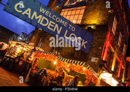 Entrée de Camden Lock. Grand panneau bleu 'Bienvenue à Camden Lock', à l'entrée du marché. En début de soirée, l'éclairage orange chaud et calme, les étals de marché. Banque D'Images