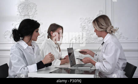 Femme médecin paie l'argent pour les infirmières en exercice. Banque D'Images