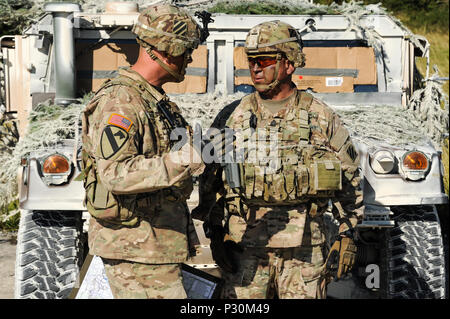 Le colonel de l'armée américaine Phil Brooks, gauche, commandant de la 1st Armored Brigade Combat Team, 3e Division d'infanterie, et de ses hauts enrôlés advisor Sgt. Commande Le major James Wafe discuter de la situation au cours de l'exercice Combined Résoudre VII à la 7ème commande d'entraînement de l'armée à Grafenwoehr, Allemagne, le 18 août 2016. Résoudre un combiné est dirigée par les États-Unis un exercice conçu pour préparer les forces américaines et européennes pour les opérations multinationales. L'exercice est conçu pour former les forces de l'armée affectés à l'échelle régionale pour les États-Unis en Europe. Résoudre combiné VII comprend plus de 3 500 participants de 16 l'OTAN Banque D'Images