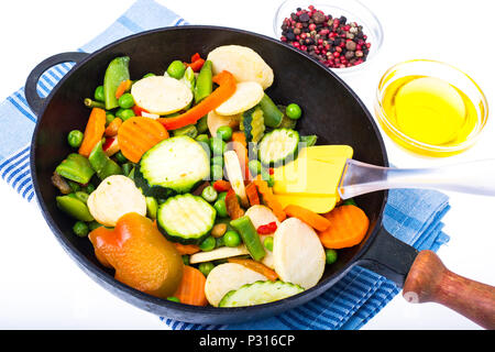 Mélange de légumes surgelés rapidement dans une poêle à frire sur fond blanc. Studio Photo Banque D'Images