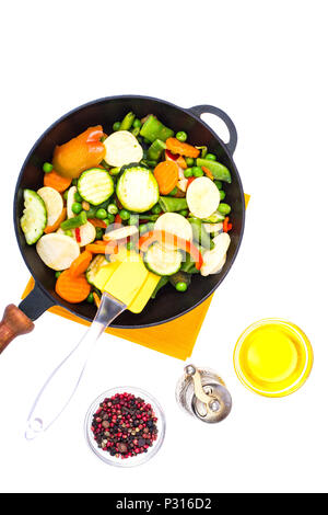 Mélange de légumes surgelés rapidement dans une poêle à frire sur fond blanc. Studio Photo Banque D'Images