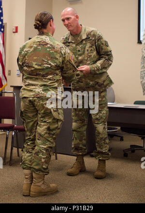 Le Sgt. 1re classe Megan Blosch, de Bristow, Nebraska, reçoit son équipage cannon (13B) certificat d'achèvement de son instructeur, le Sgt. 1re classe Keith Glenn à l'Institut régional de formation à Oklahoma City, le 22 août 2016. Blosch est l'une des premières femmes d'équipage qualifiés dans l'Oklahoma cannon Army National Guard (OKARNG). Parmi les finissants sont trois autres OKARNG les femelles, qui a également obtenu le diplôme de l'OKARNG premier équipage féminin qualifié Cannon. Ce processus rigoureux et exigeant physiquement les soldats apprennent à un éventail de compétences et de l'accent sur l'identification des différents types Banque D'Images