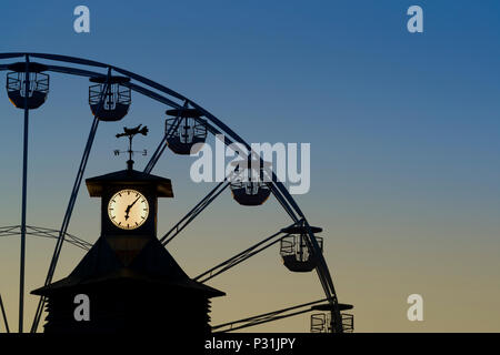 Le réveil de la jetée de Bournemouth avec la grande roue à l'arrière-plan tourné contre un ciel du soir. Banque D'Images