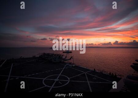 À BORD DU USS GREEN BAY (LPD-20), (16 août 2000 21, 2016) - Le soleil se couche sur l'USS Green Bay (LPD-20) à White Beach Base Navale, Okinawa, Japon, le 21 août, 2016. Marines de la 31e MEU sont actuellement engagés sur les navires de l'USS Bonhomme Richard pour groupe expéditionnaire d'un service de patrouille de l'automne de la région Asie-Pacifique. La 31e MEU est le Marine Corps' seulement continuellement de l'avant-déployé, Groupe de travail air-sol marin et est organisée à la tâche de s'attaquer à toute une gamme d'opérations militaires dans la région de l'Asie-Pacifique, de la projection et de la sécurité maritime à l'aide humanitaire et des re Banque D'Images